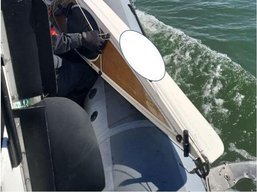 En kajak lyfts upp i en båt.