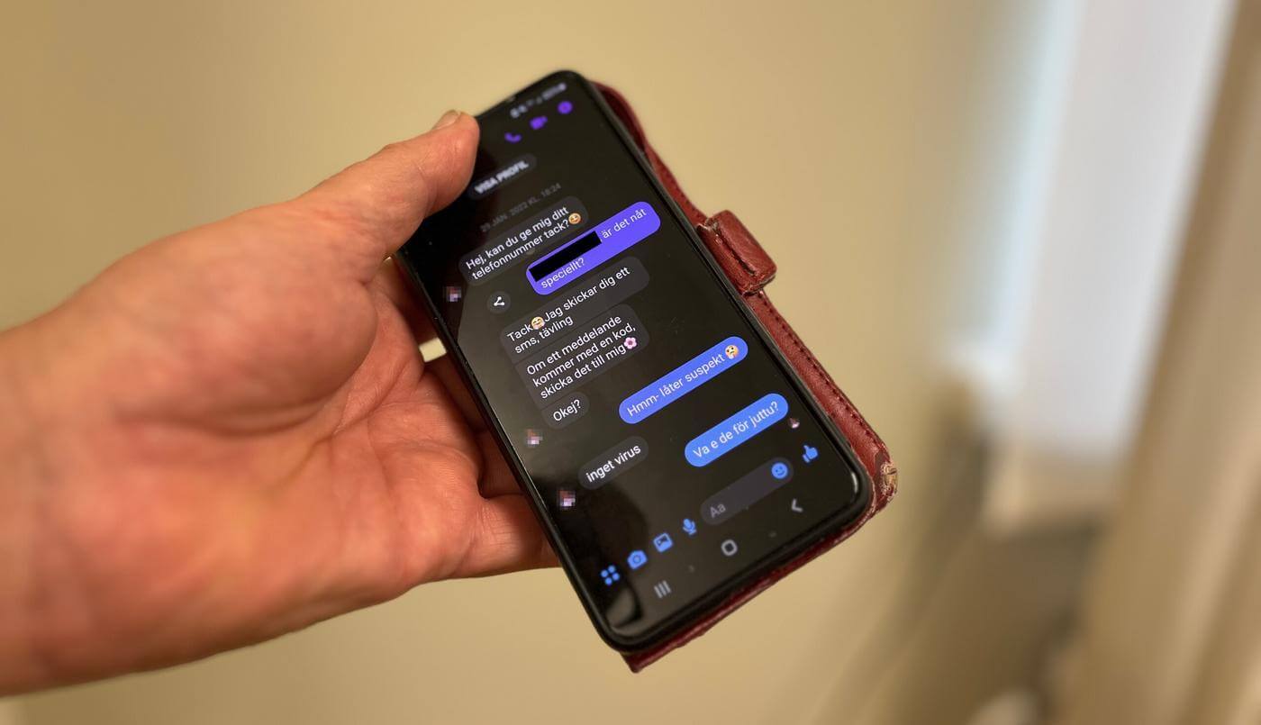 Hand som håller i en smarttelefon, på skärmen syns en textmeddelandekonversation