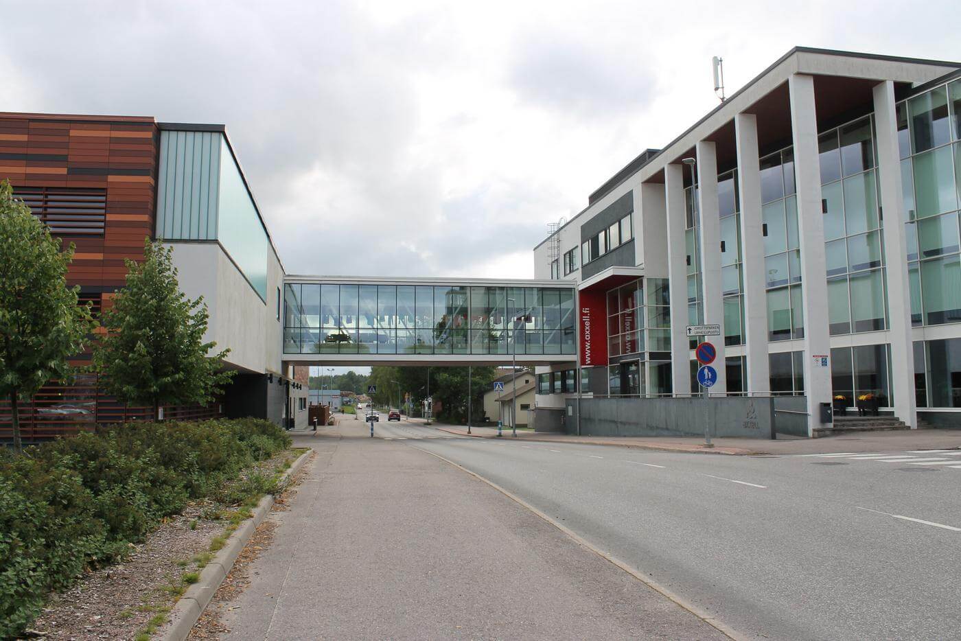 Axxells skolbyggnad i Karis. På bilden ser man en väg som går mallan de två skolbyggnaderna och en glas gång som går över vägen och kopplar ihop skolbyggnaderna.